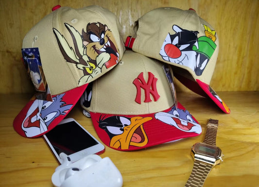 Gorra curva Coleccion Looney Tunes Color Beige con visera Roja con Diseños de Personajes
Favoritos y Logotipo NY