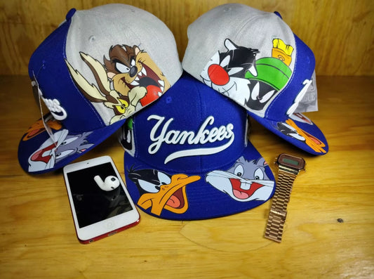 Gorra plana Coleccion Looney Tunes Color Azul
Rey con Gris con Diseños de Personajes Favoritos y Logotipo Yankees